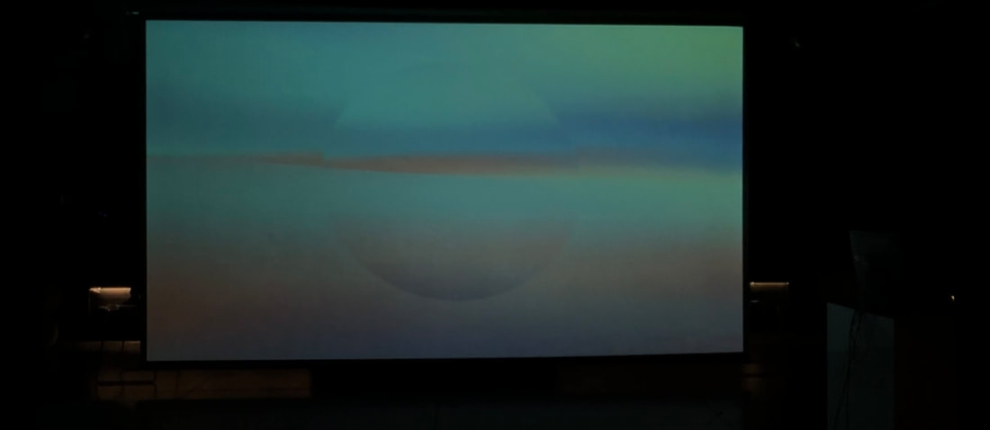 SUNSET installation projected in a dark exhibition space